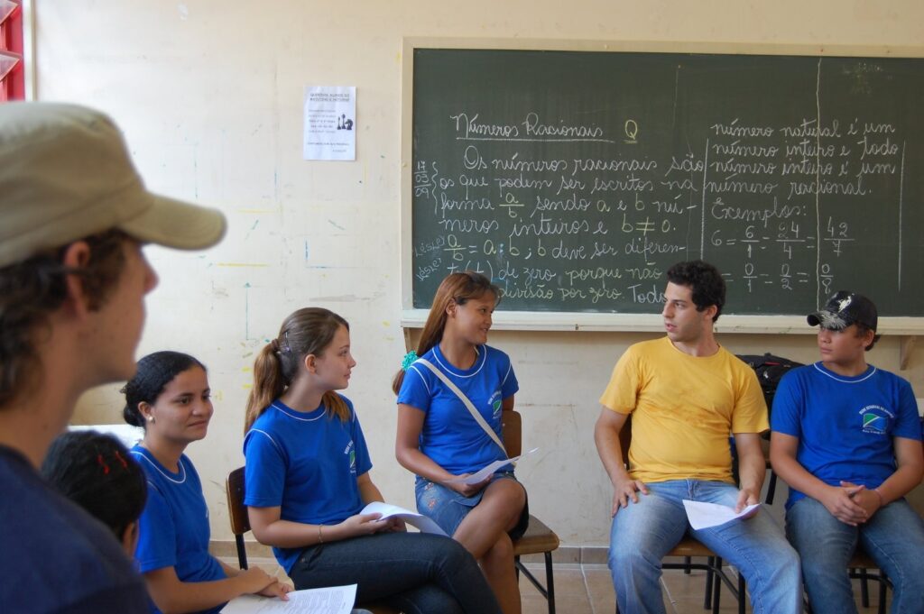 Grupo sentado em círculo durante oficina em sala de aula