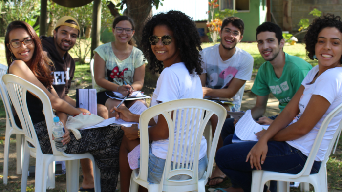 Estudantes em estudo bíblico sorriem pra foto