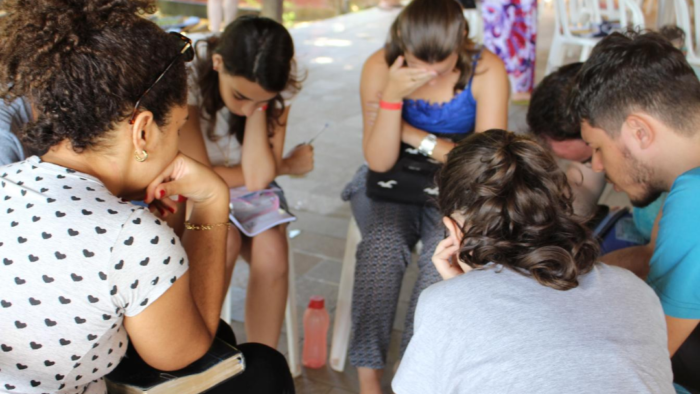 Estudantes em oração num círculo