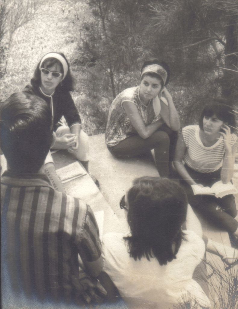 Estudantes sentados em círculo conversam em acampamento de 1965